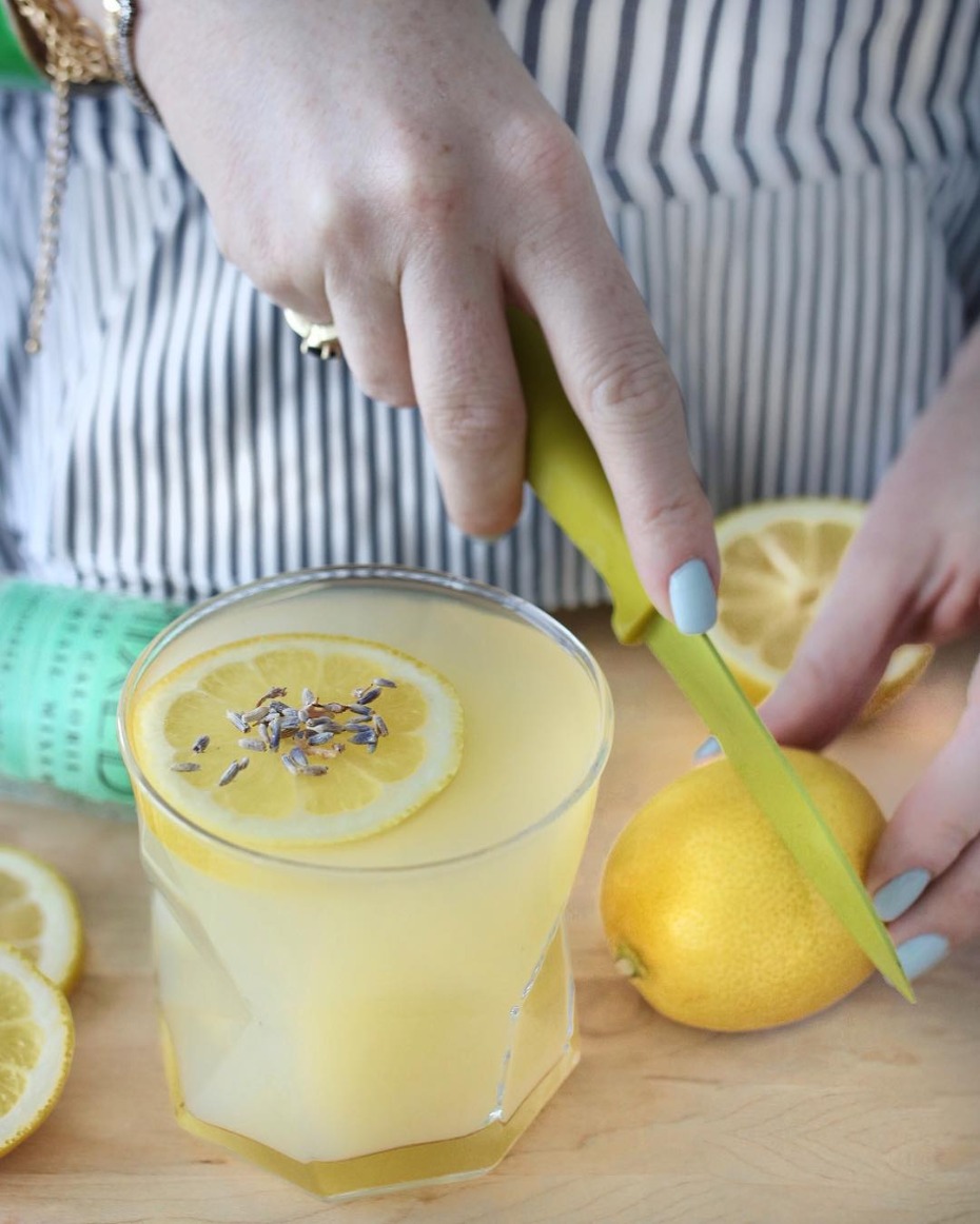 Making a lemon drink with lavender garnish, a perfect cocktail