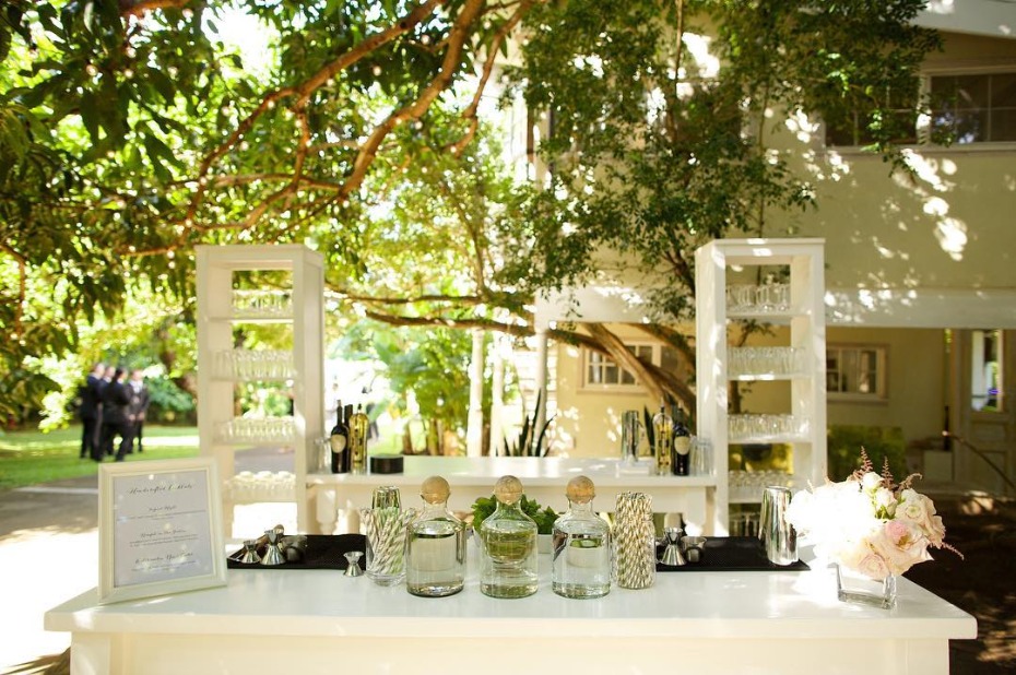 Outdoor wedding bar setup with drinks and flowers