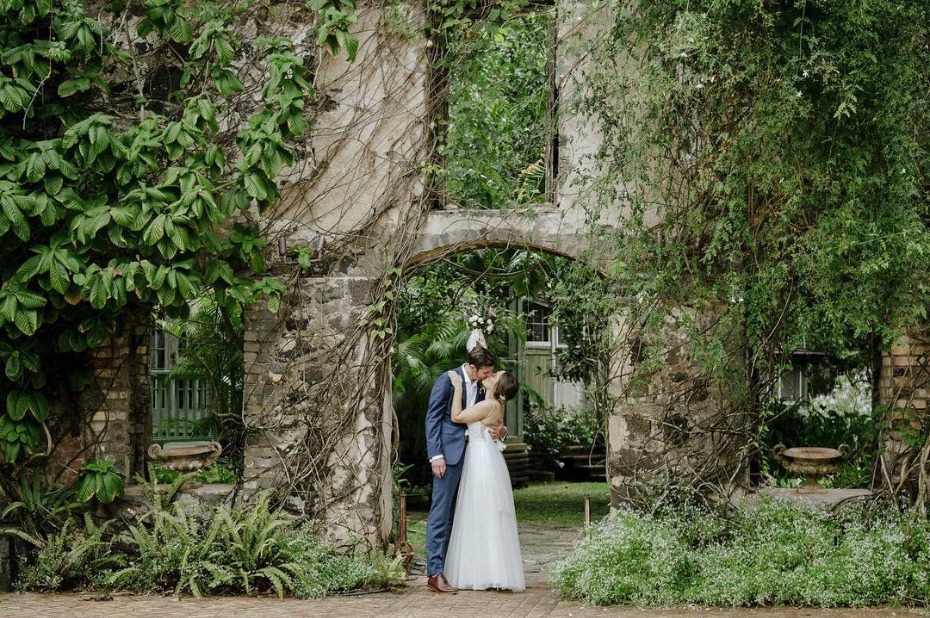 Romantic kiss in a vintage garden archway wedding photo