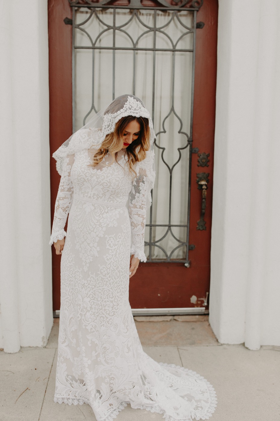 Bride standing with dress fanned out and curls in her hair