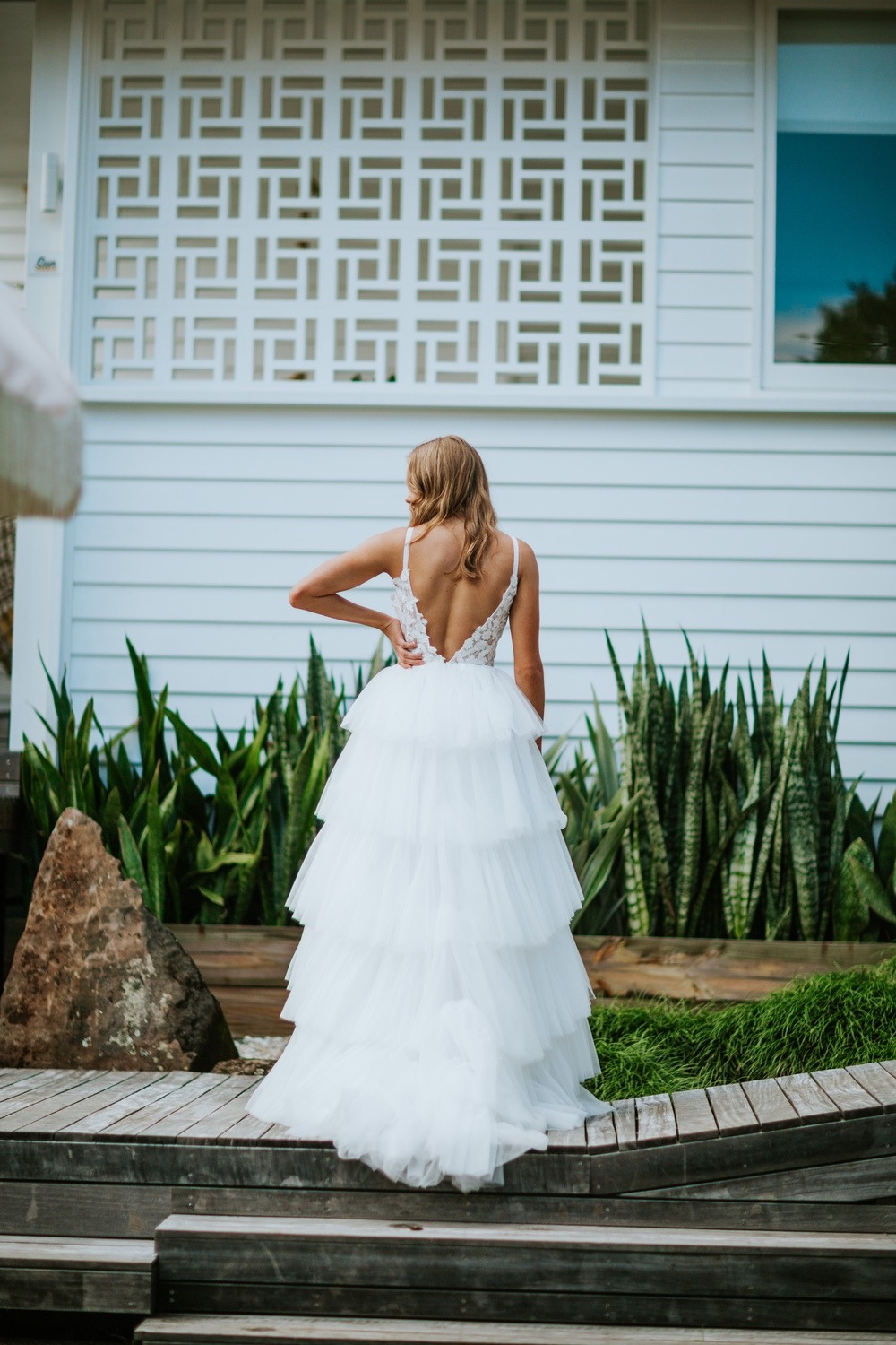 Woman in tiered white wedding gown outdoors