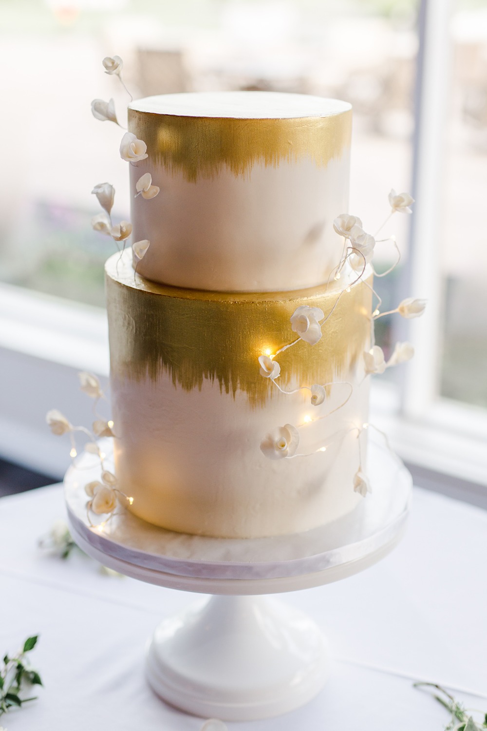 gold leaf painted cake with fairylight accents
