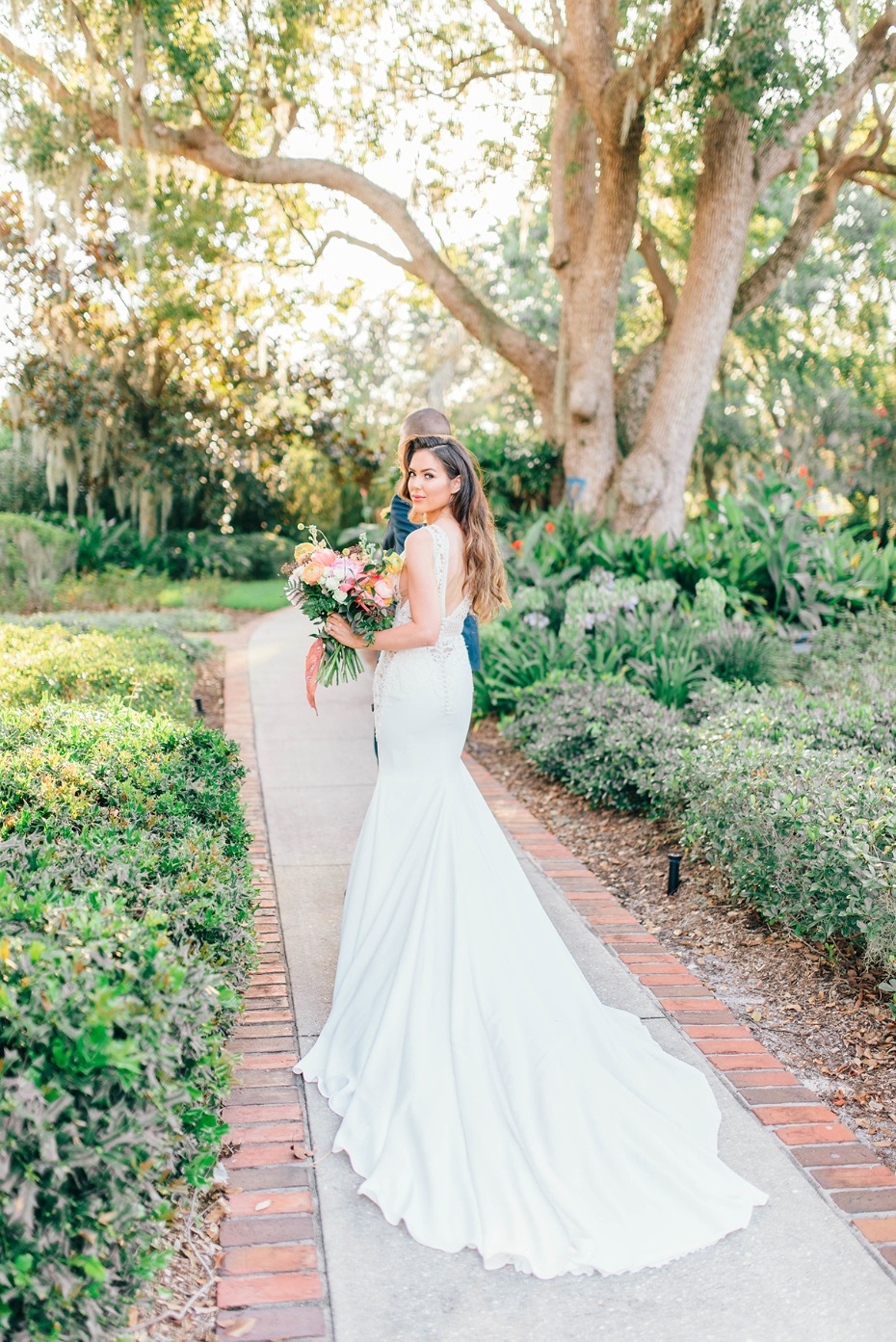 Bride with bouquet in wedding dress looks back