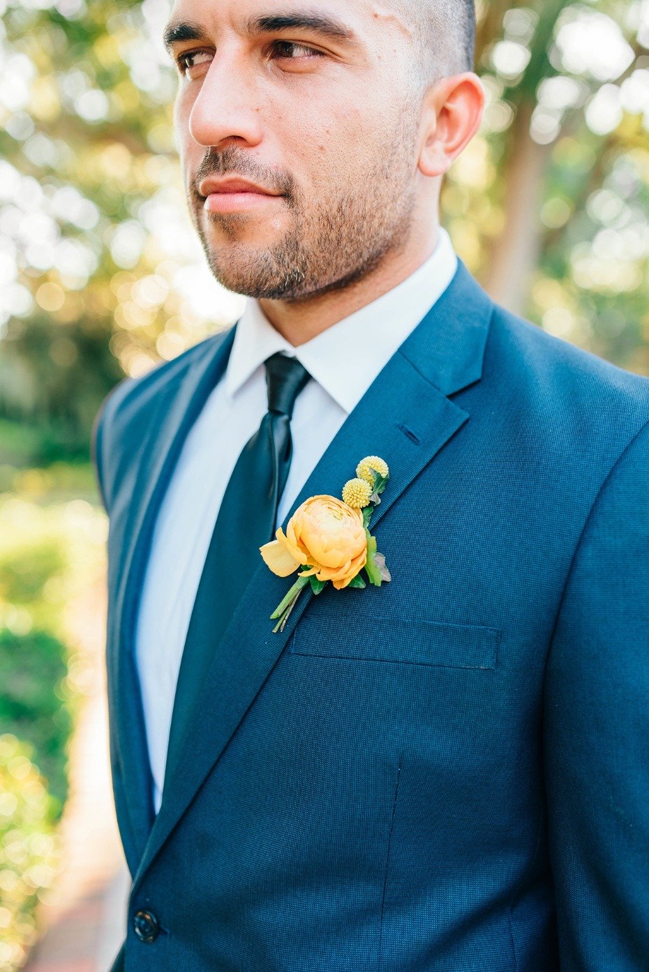 groom in blue suite and golden floral boutonniere
