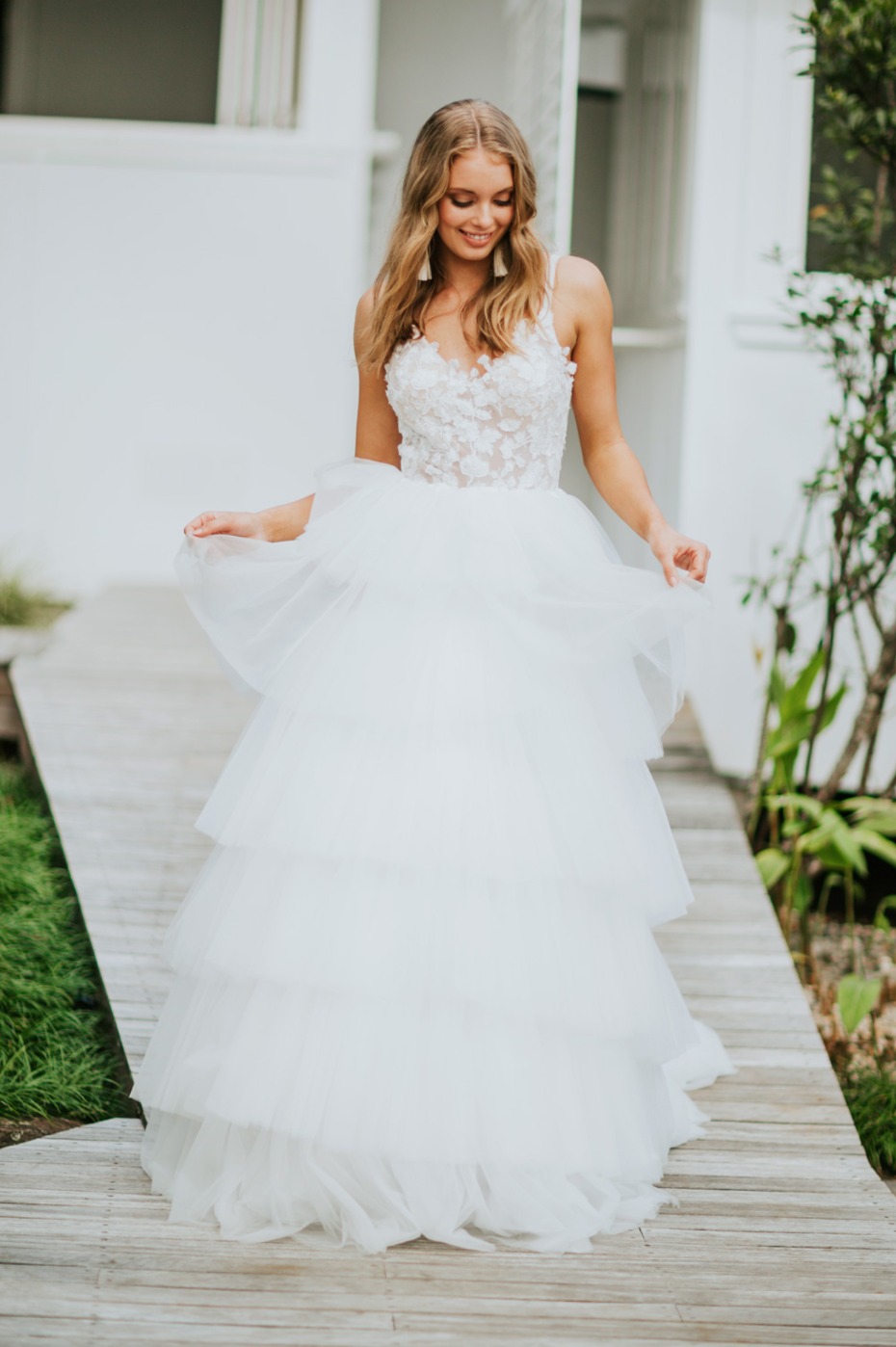 Blonde bride in a tiered tulle wedding dress smiles