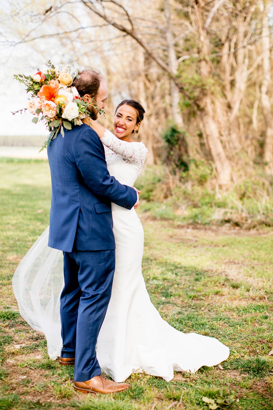Bride smiling at groom holding bouquet on wedding day