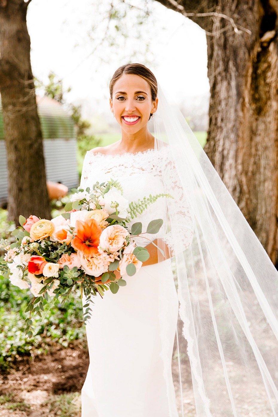 Happy bride smiles holding a colorful bouquet at her wedding