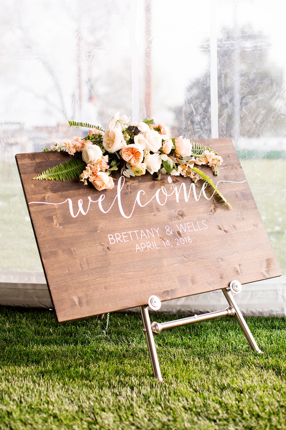 Welcome wedding sign with floral arrangement outdoors