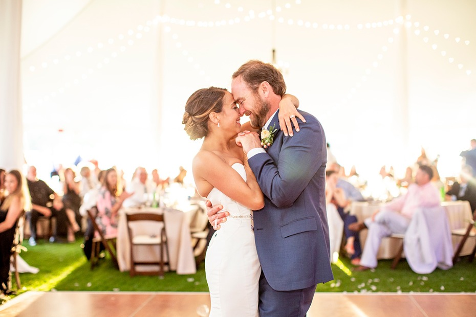Bride and groom share a first dance at wedding reception in a tent
