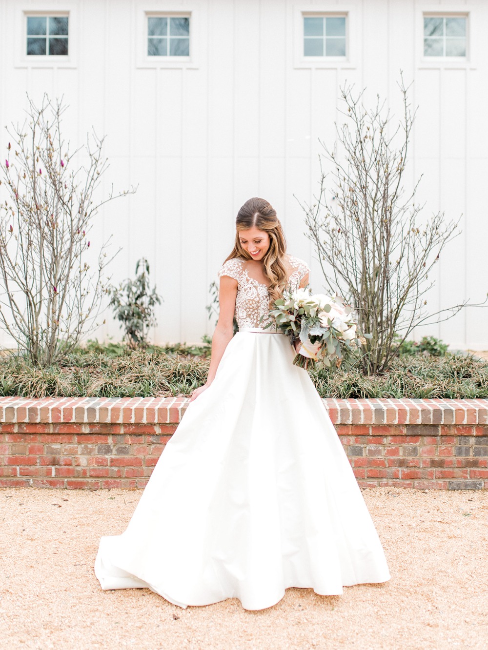 Elegant bride in a white dress holding a bouquet of flowers, smiling