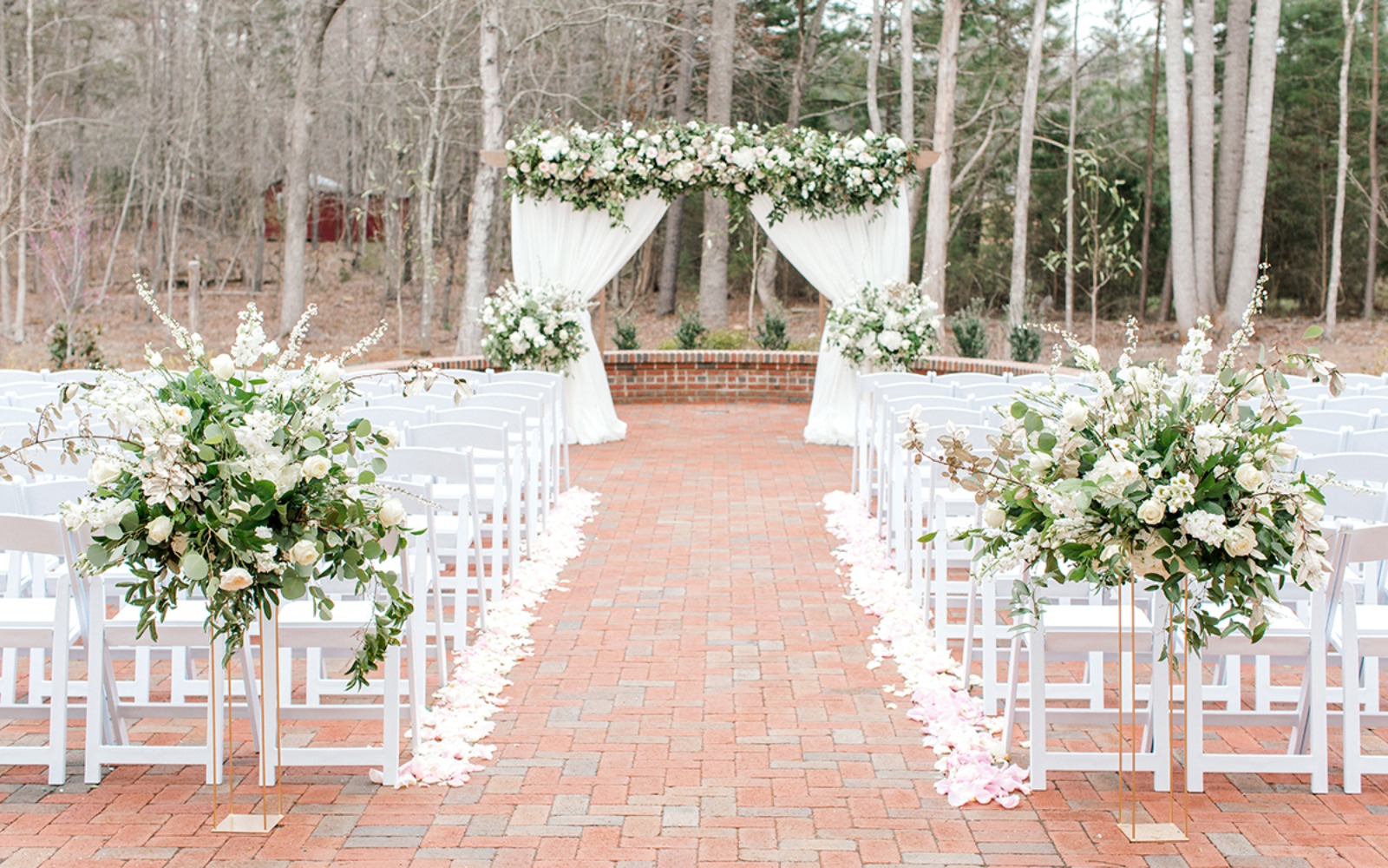 Elegant outdoor wedding ceremony setup with floral arch and chairs
