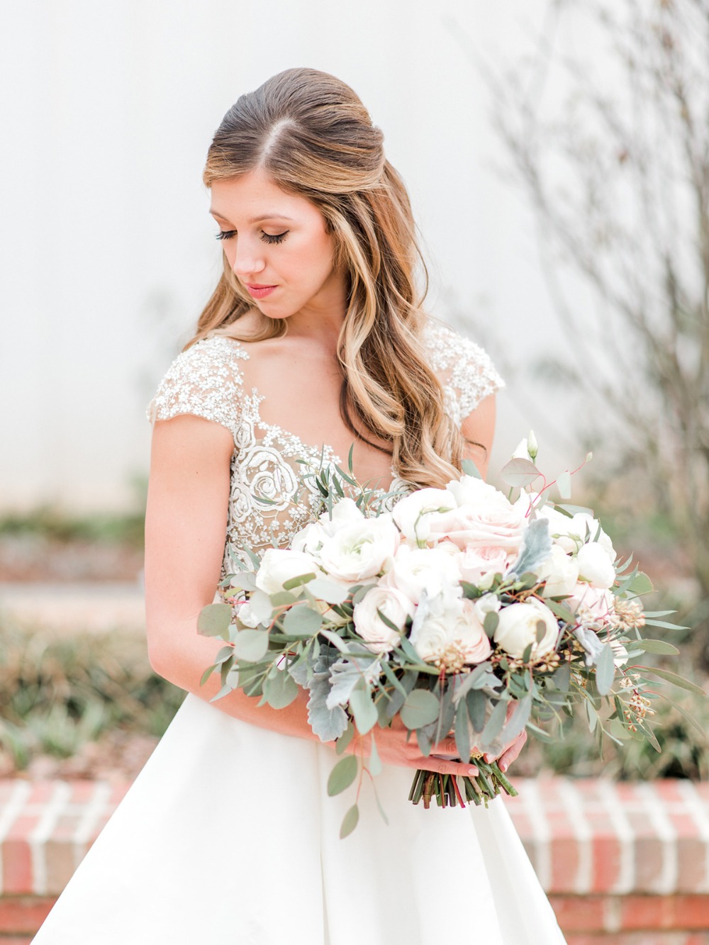 Elegant bride holding a beautiful wedding bouquet in soft light