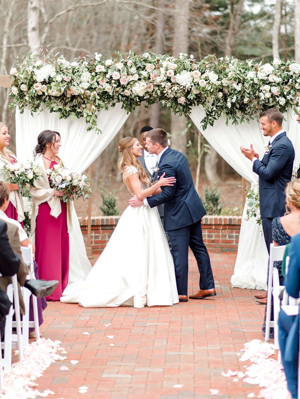 Bride and groom share a kiss at beautiful outdoor wedding