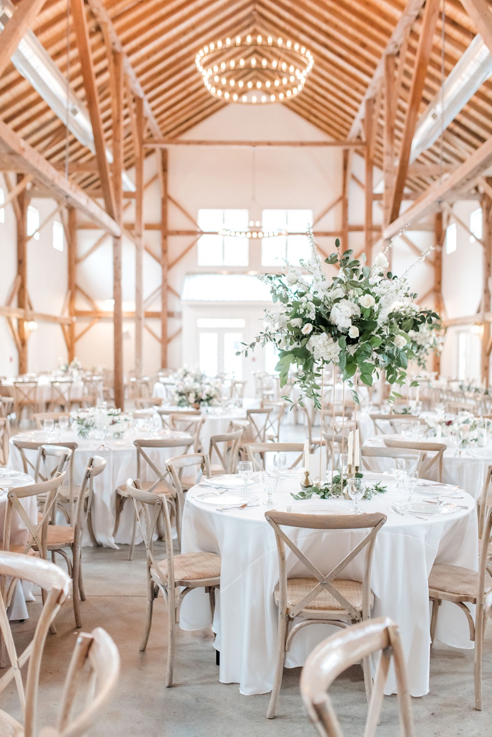 Elegant wedding reception tables set in a rustic barn venue