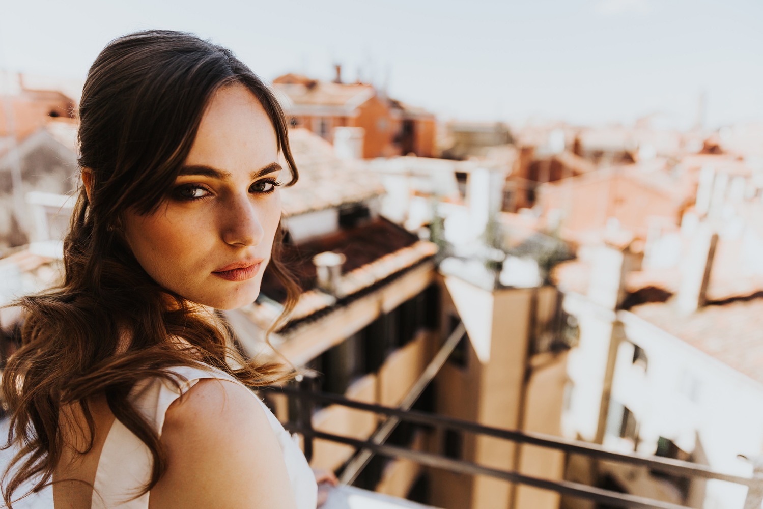 Woman overlooking city rooftops with a knowing look on her face