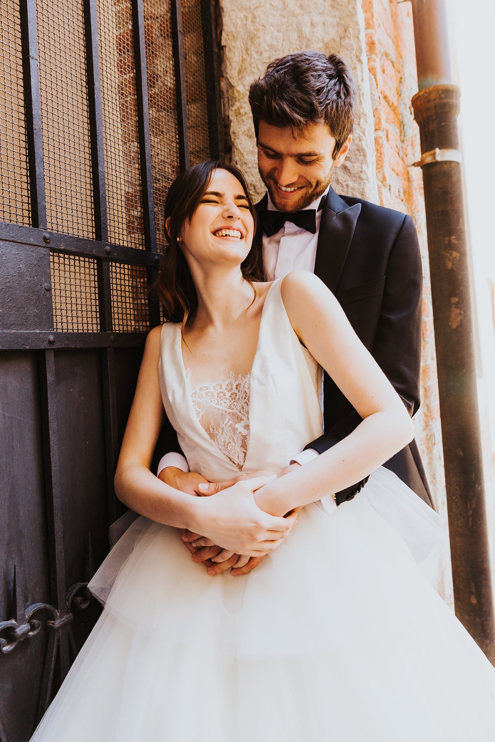 Joyful bride and groom embrace and laugh on their wedding day