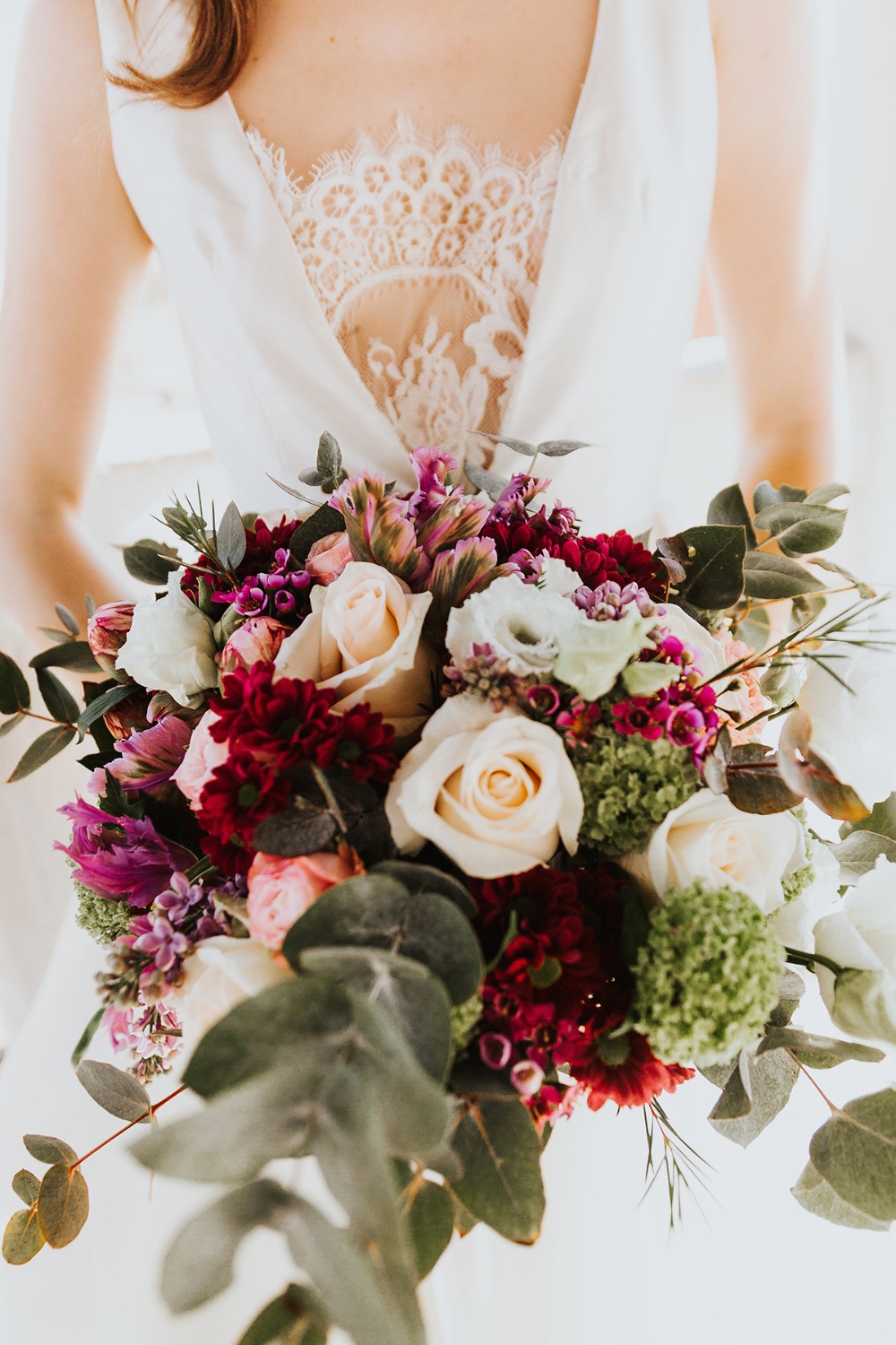 Bride in white dress holding romantic wedding bouquet