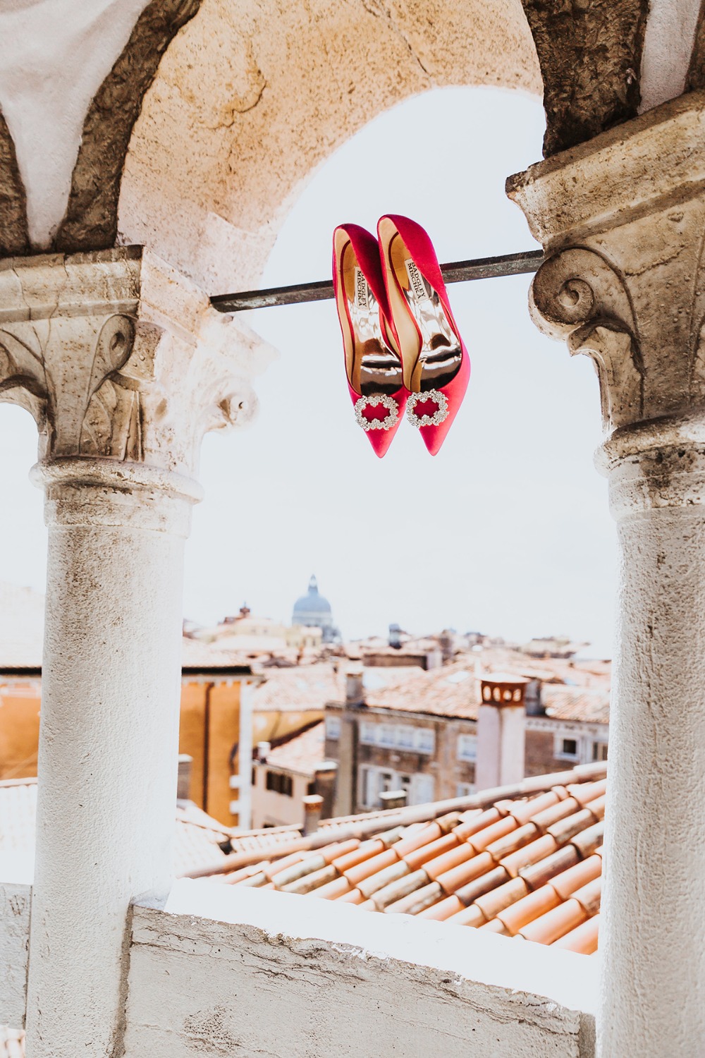 Red wedding shoes with Venice rooftops in background