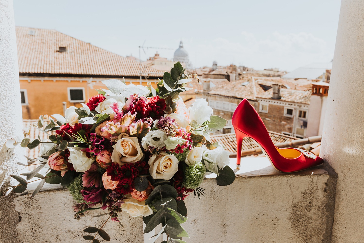 Wedding bouquet and red shoe Venice cityscape background