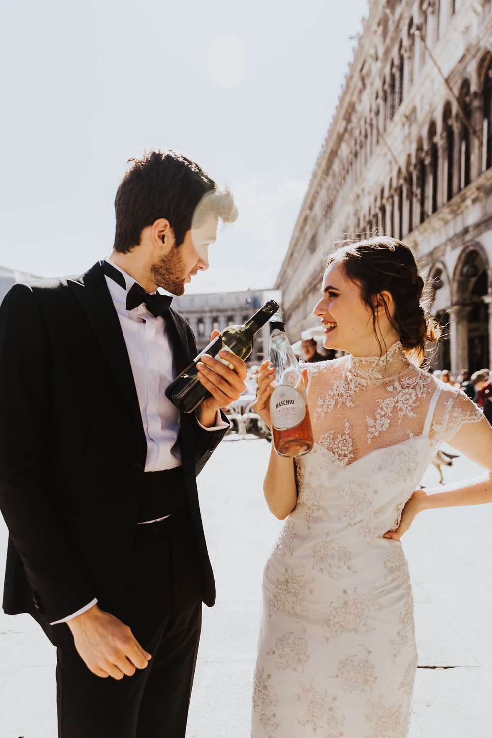 Groom and bride toasting drinks in wedding clothes