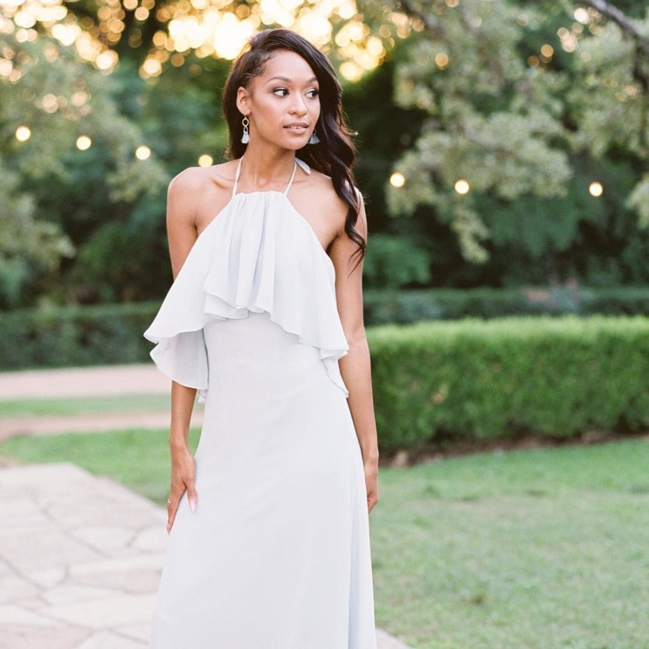 Woman in flowing blue halter dress outdoor portrait