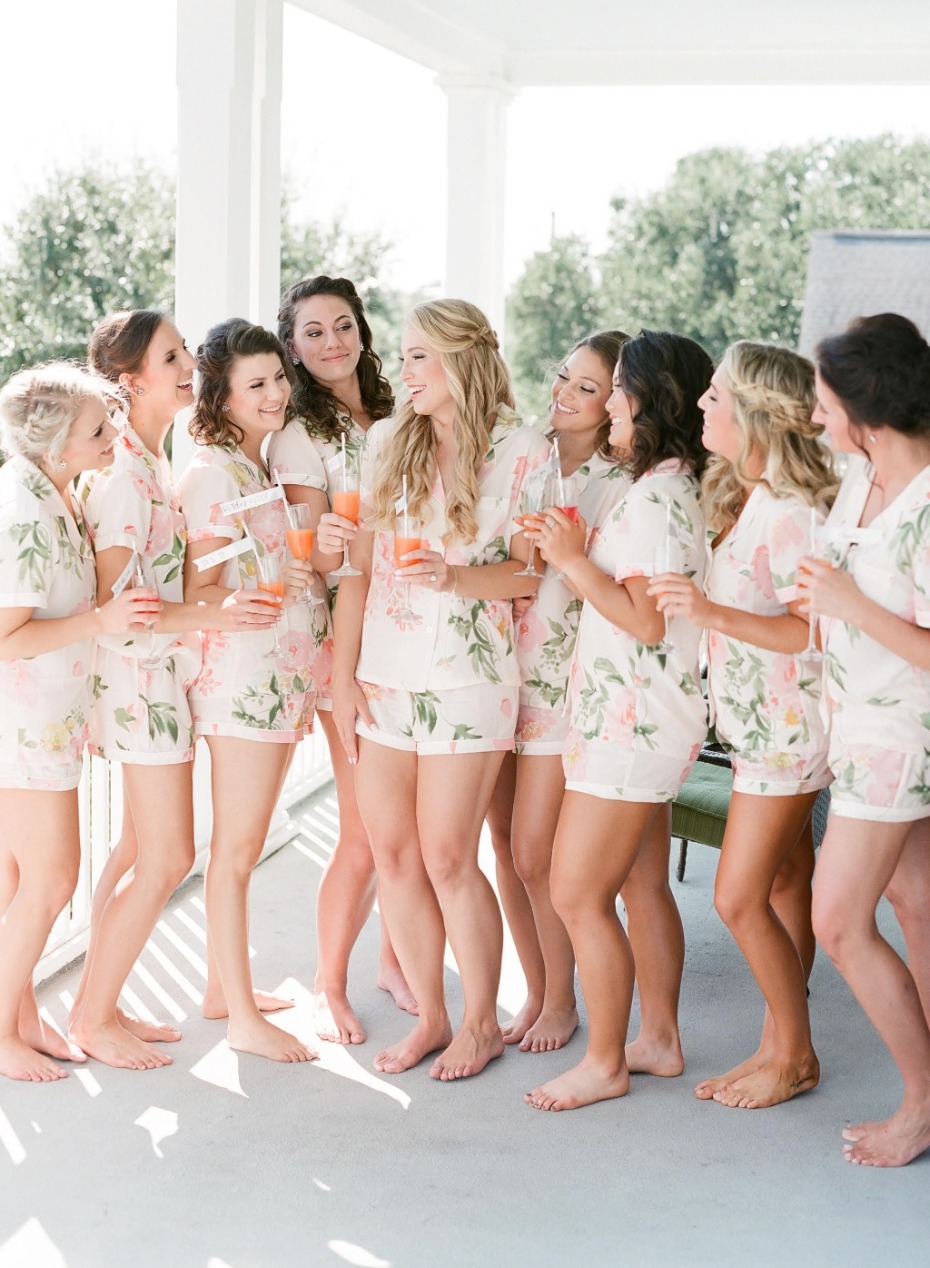 Bridesmaids in floral pajamas celebrating with drinks