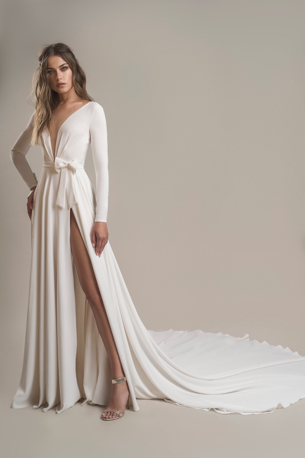 Elegant white wedding gown with a deep V neckline and slit