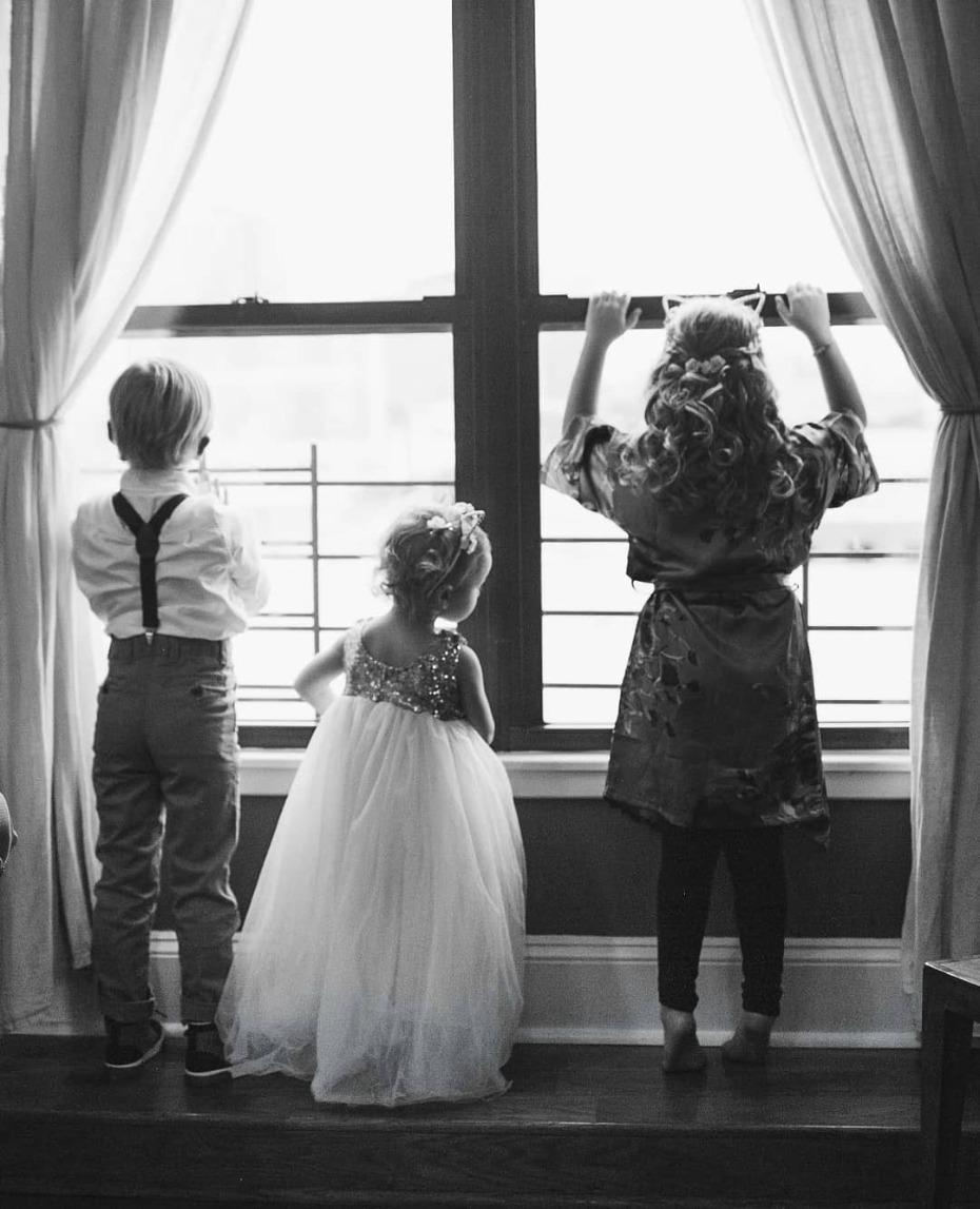 Flower girls and ring bearer staring out the window