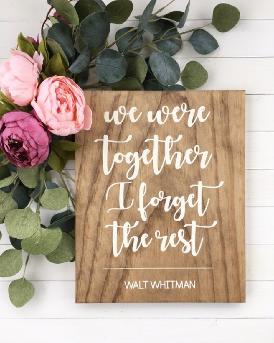 Wooden sign with a Walt Whitman quote and floral decor