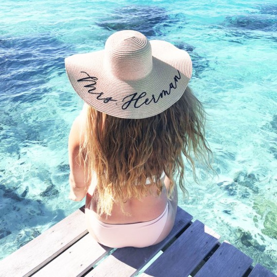Woman in a Mrs  Herman sun hat by the ocean, perfect for vacation
