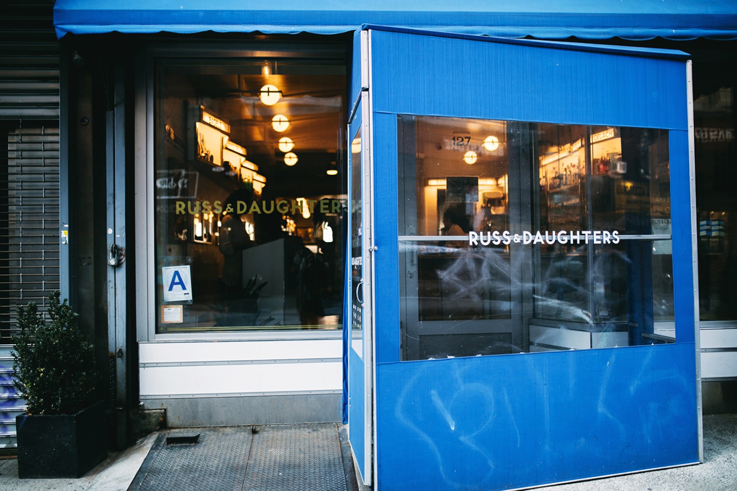 Exterior of Russ & Daughters store with a blue awning