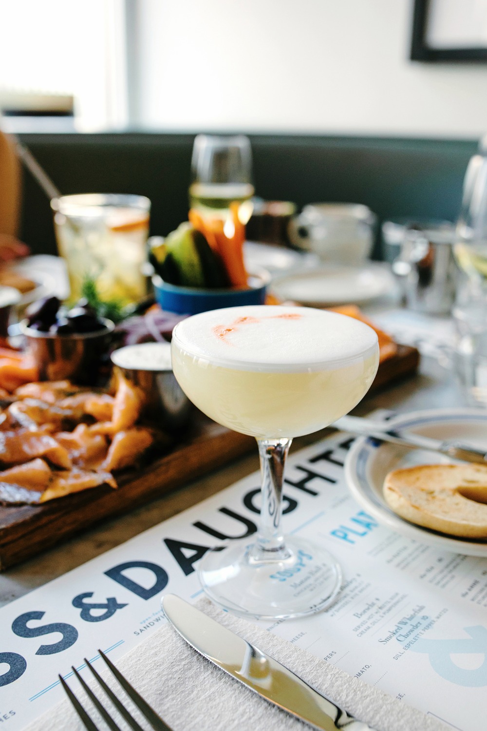 Elegant cocktail with a foamy top on a restaurant table setting