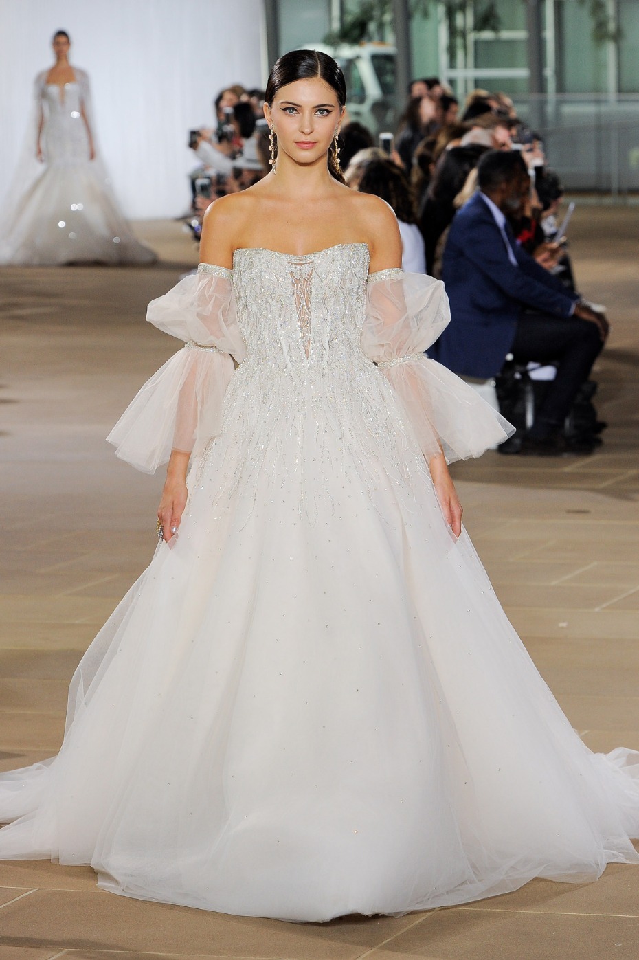 Elegant bride in a beautiful off-the-shoulder wedding gown on the runway