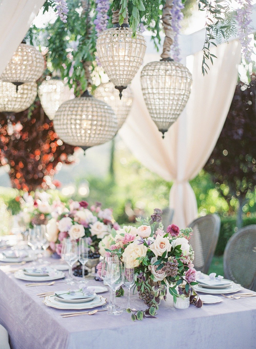 glamorous garden party table with floral and chandelier canopy