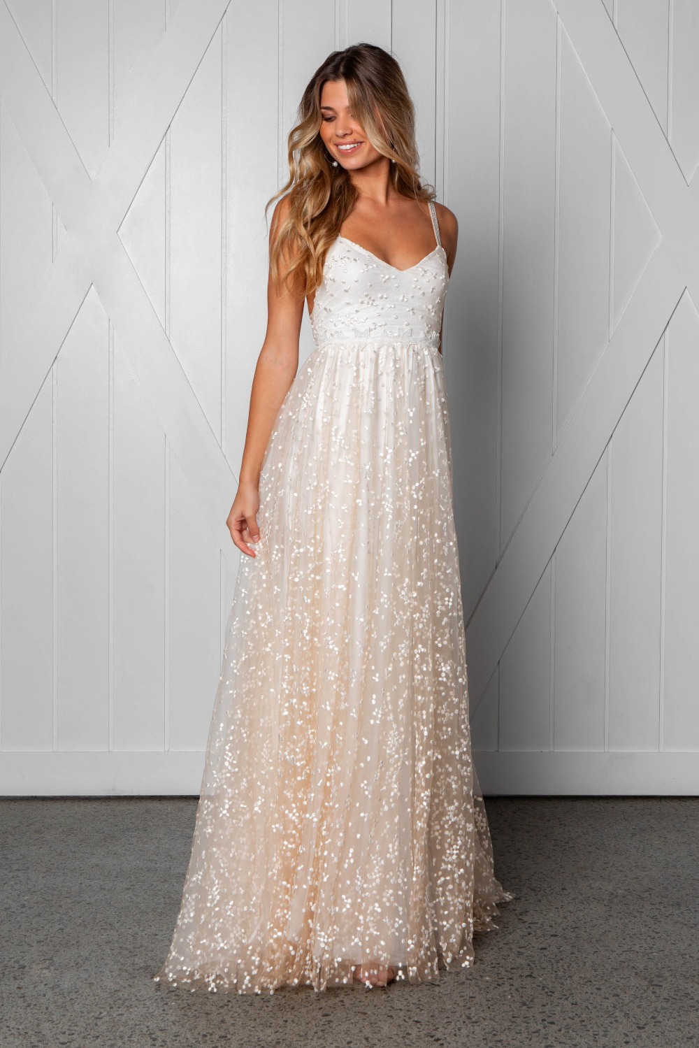 Smiling woman in long white sparkly wedding dress