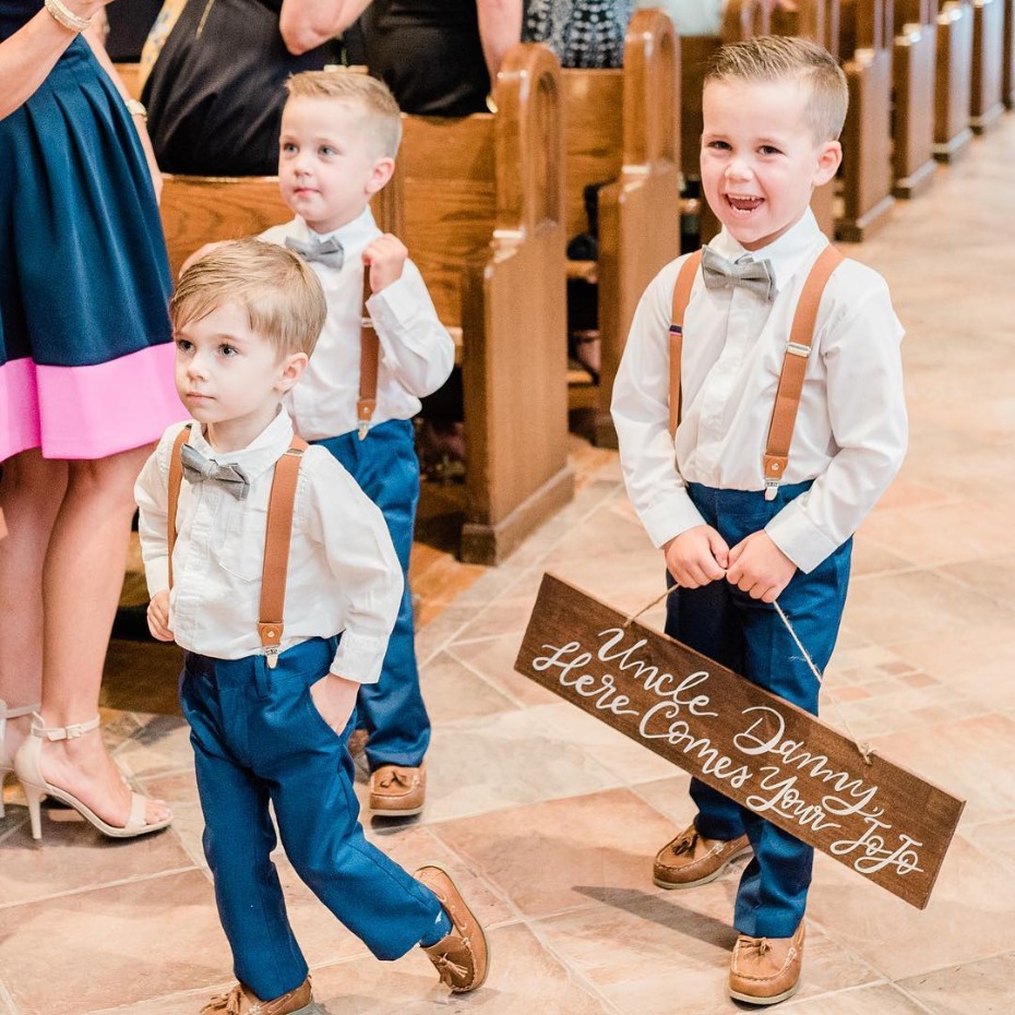 Ring bearers carrying sign down the aisle