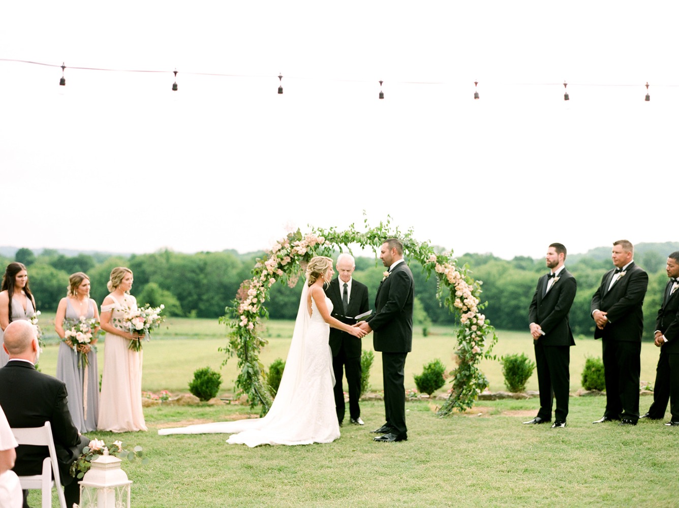 outdoor wedding ceremony with round floral arch backdrop
