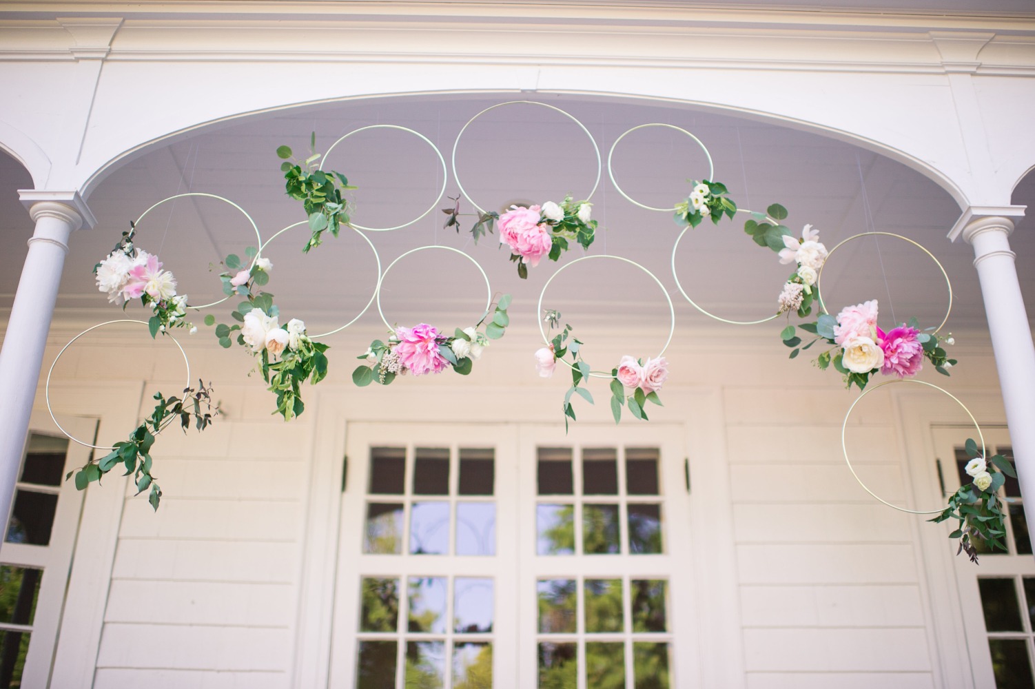 Floral hoops hanging under porch for wedding decor