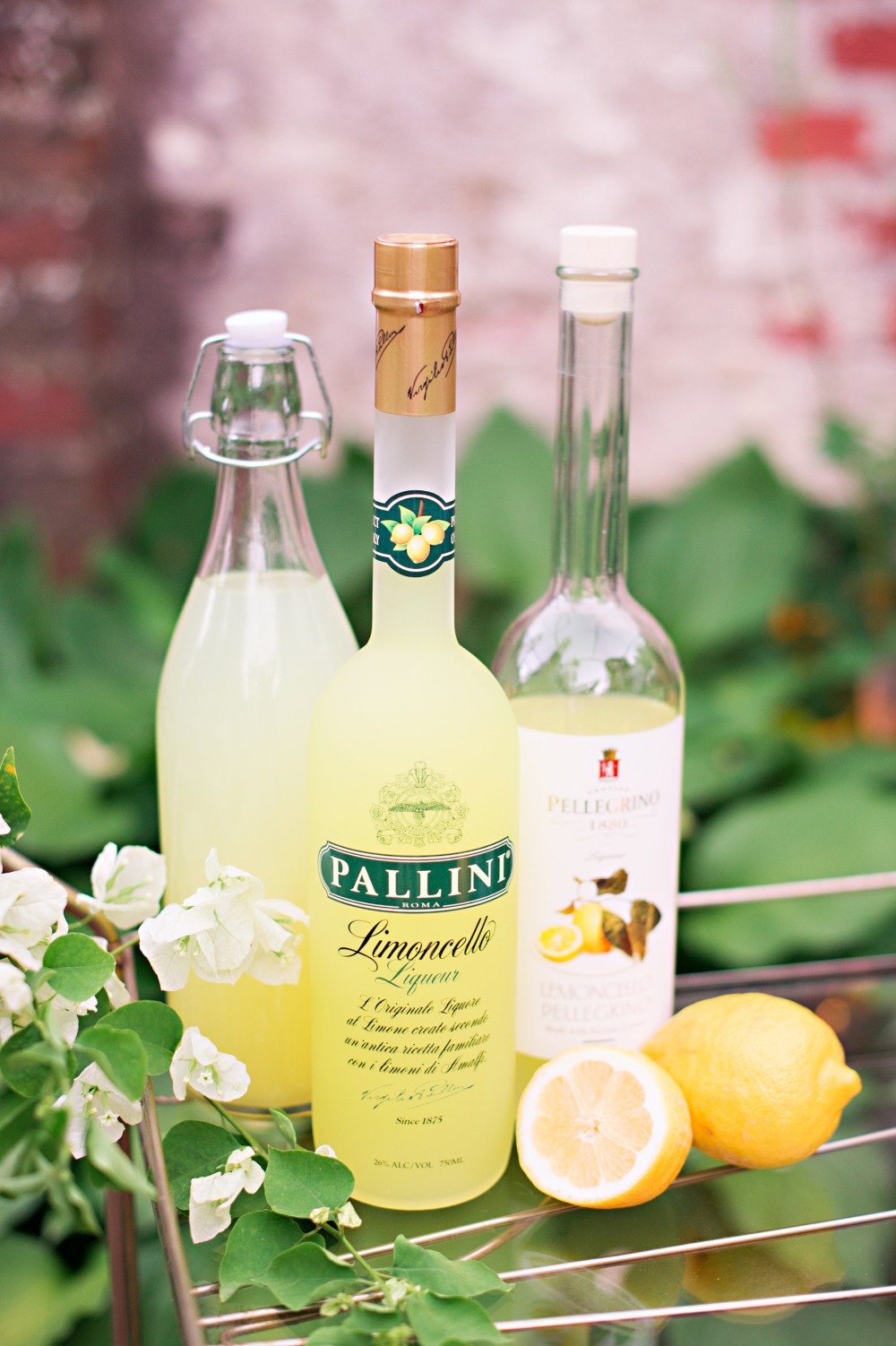 Bottles of limoncello liqueur with lemons and white flowers