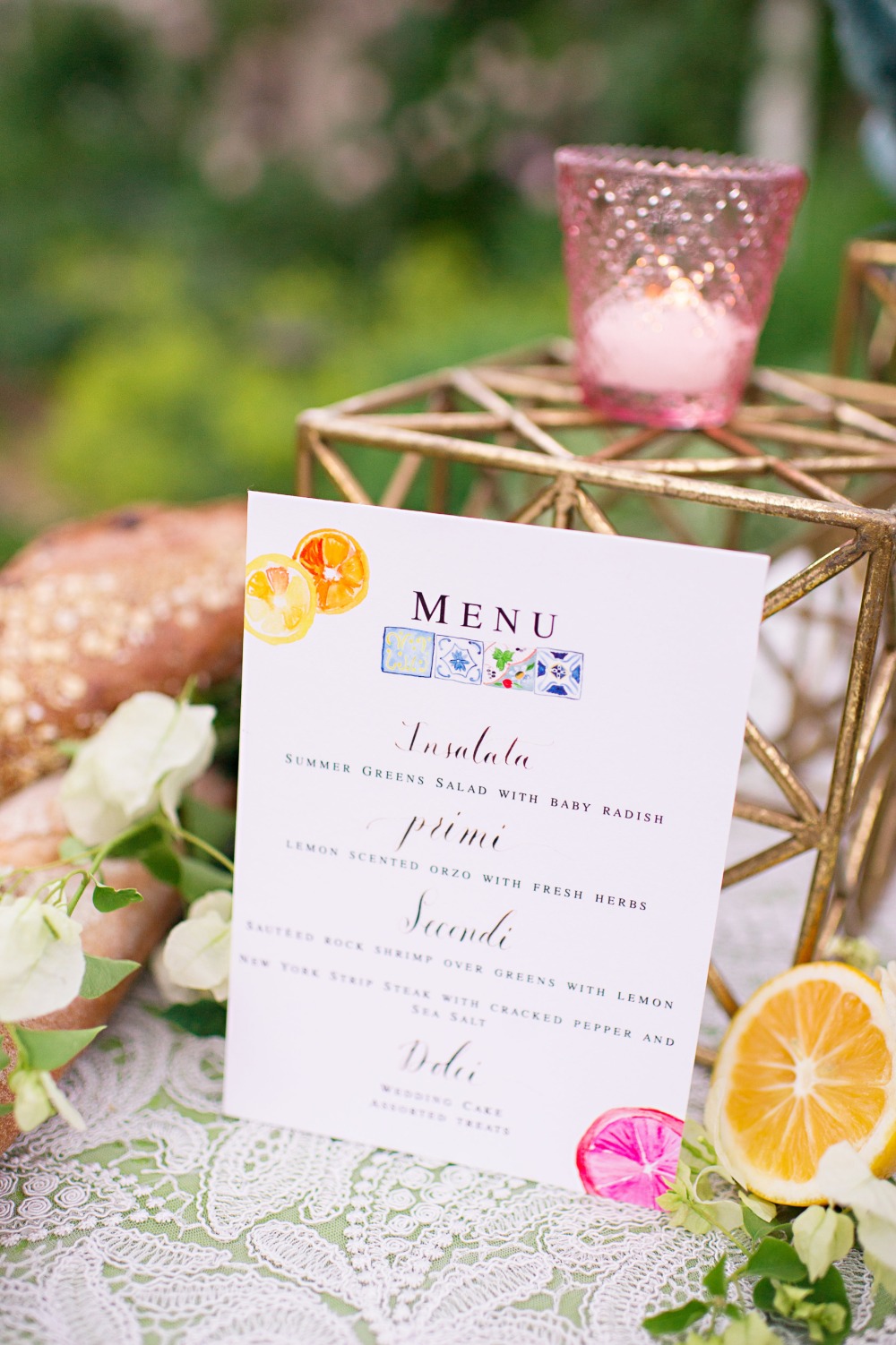 Elegant wedding menu with painted fruit and a pink candle