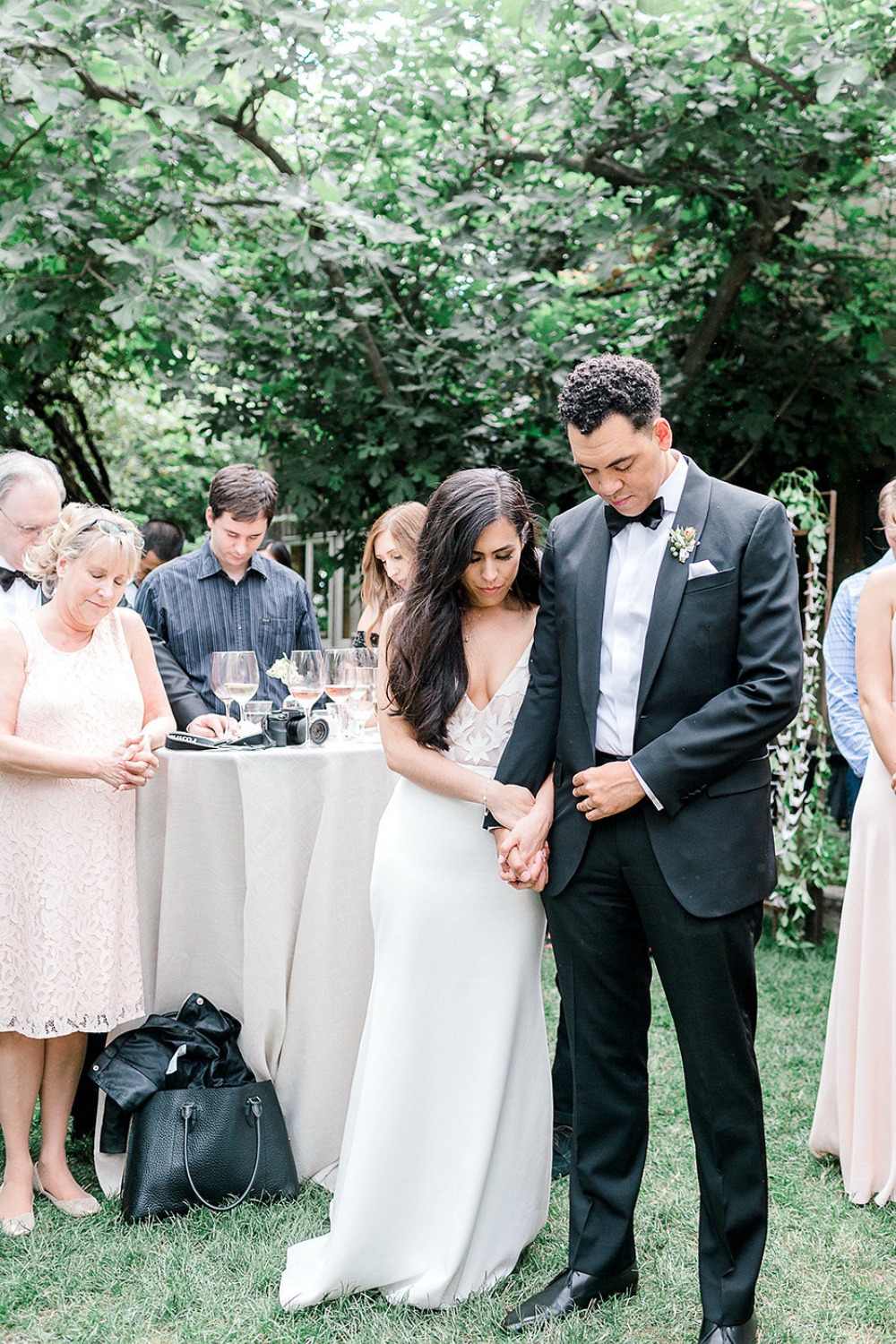 Bride and groom hold hands at outdoor wedding ceremony