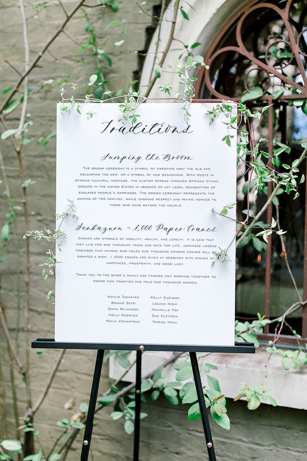 Wedding sign with traditions displayed, adorned with greenery