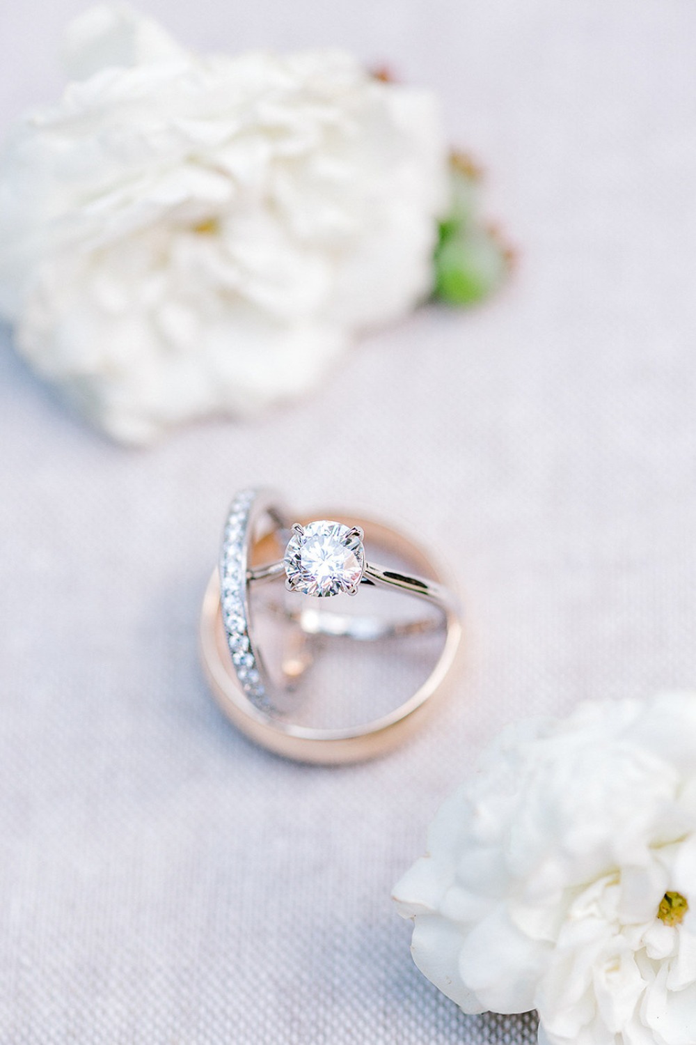 Elegant diamond engagement ring next to a wedding band with flowers