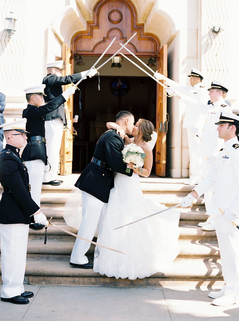 Couple shares a kiss under a military sword arch at their wedding