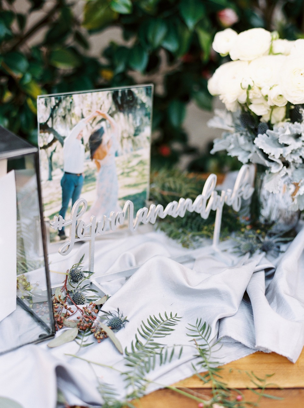 Wedding table decor with photo frame and floral arrangement