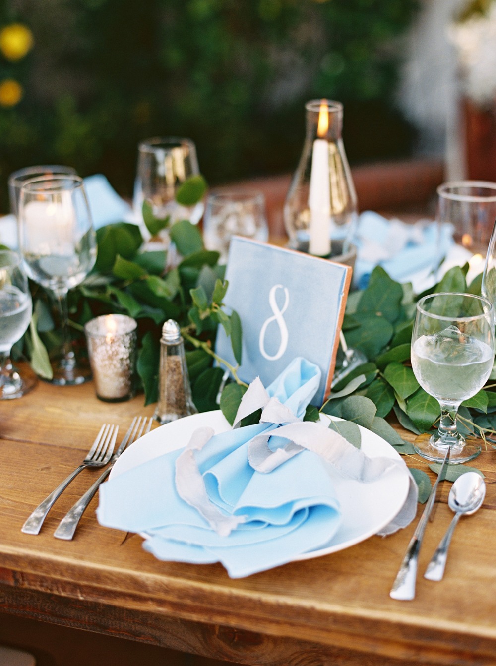 Elegant wedding table setting with blue napkins and candles