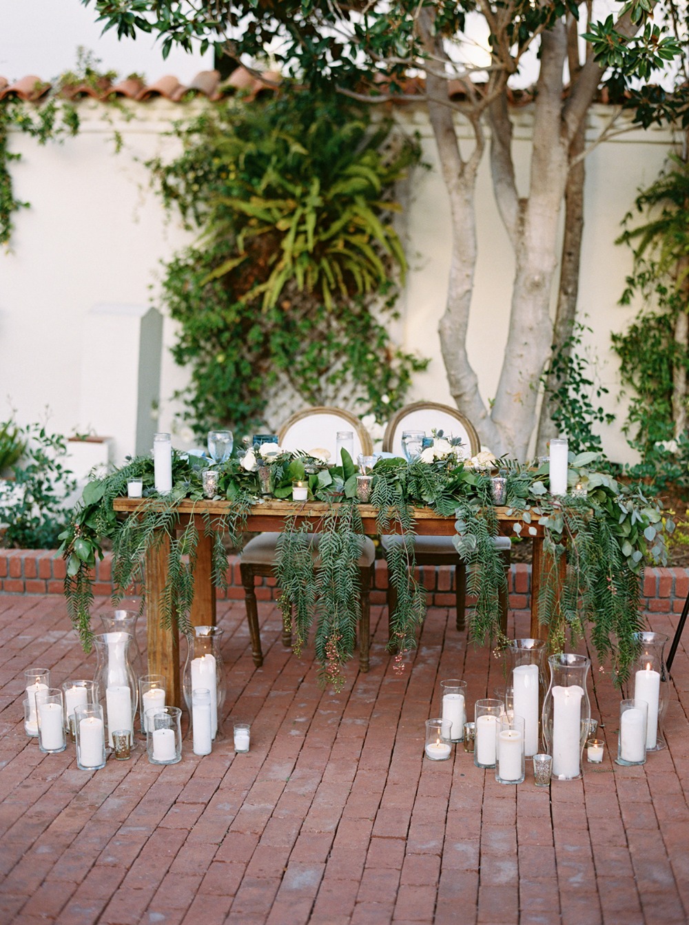 Wedding sweetheart table with candles and greenery