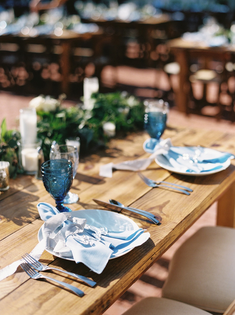 Rustic wooden wedding table setting with blue accents