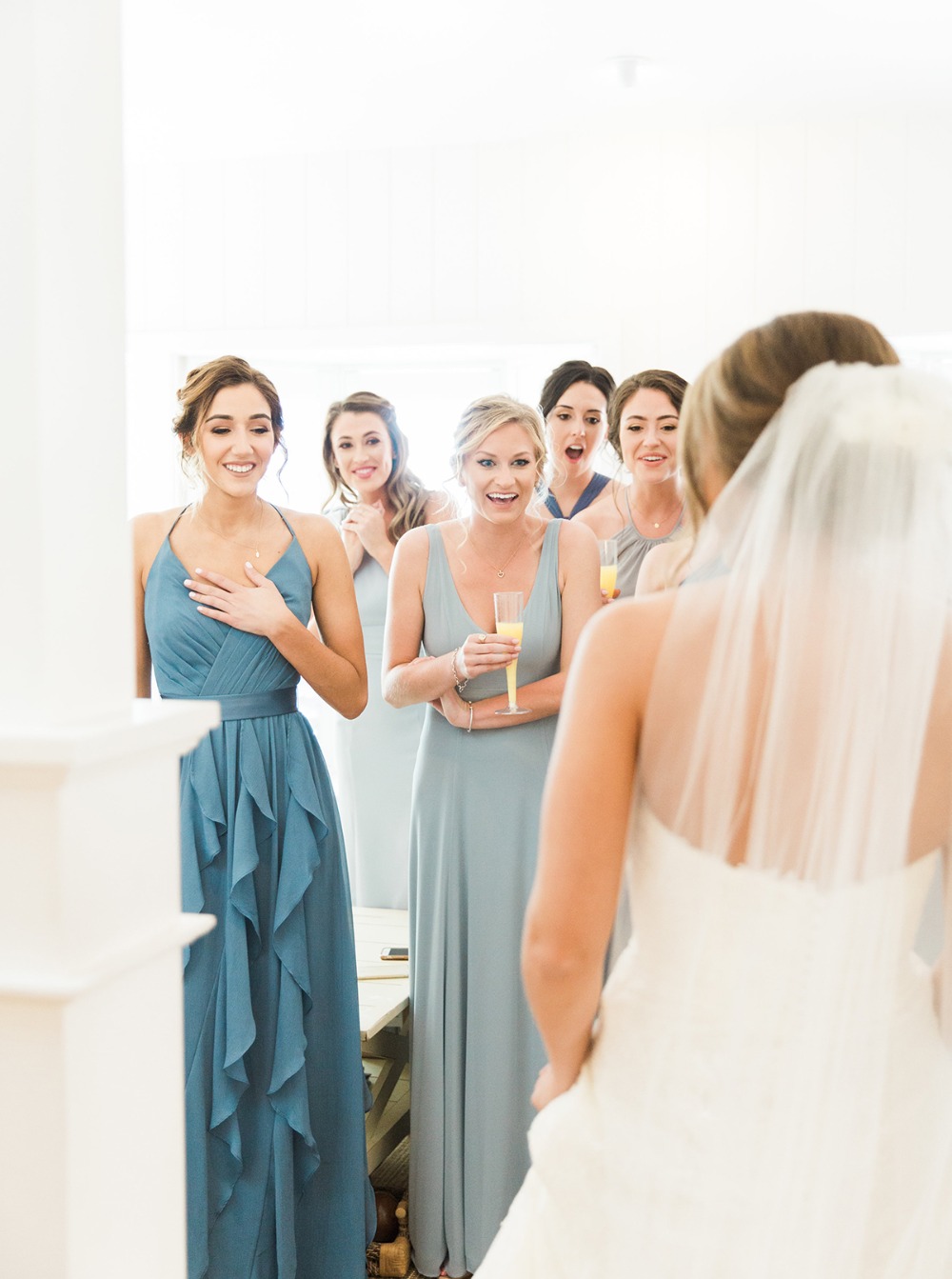 Bridesmaids react to seeing the bride in her wedding dress