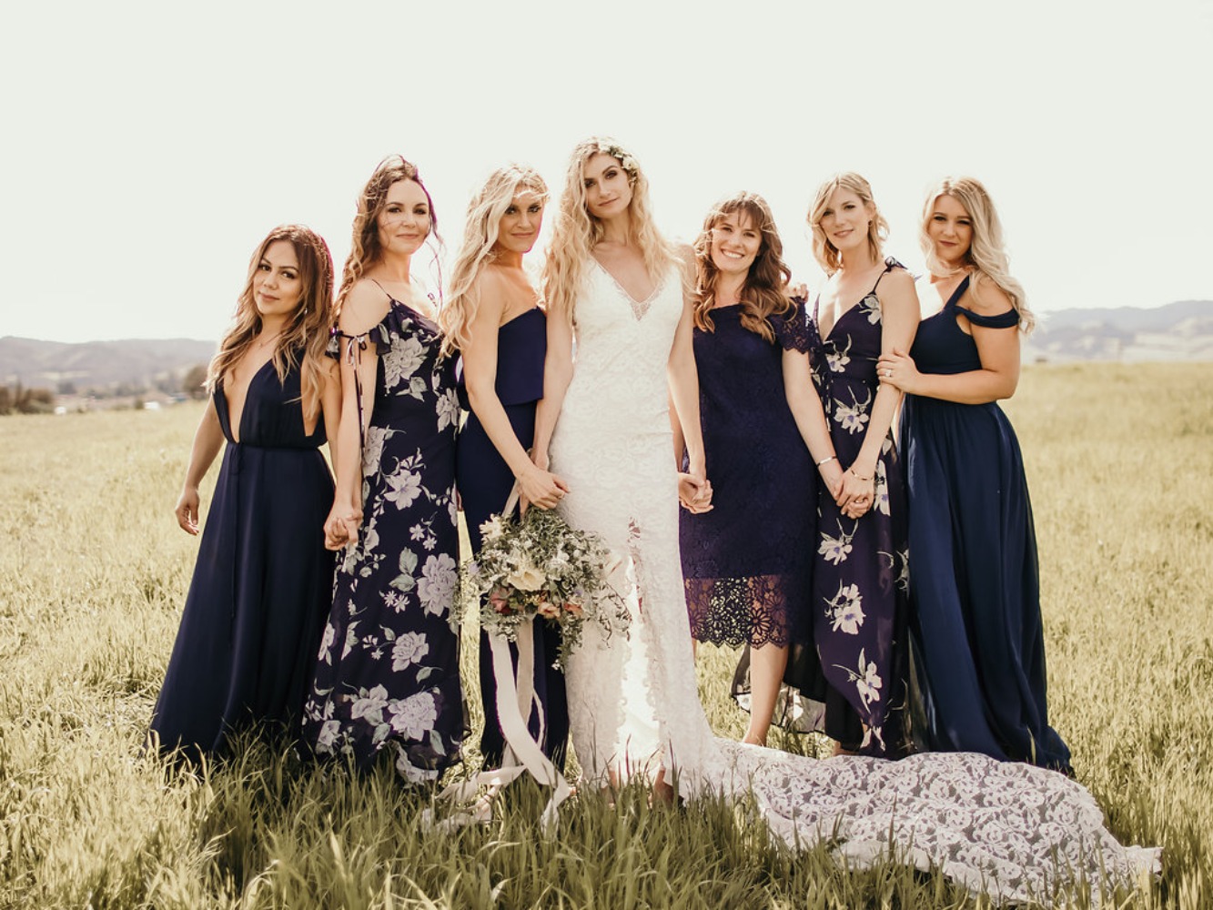 the bride and her bridesmaids in mismatched navy